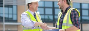 Construction professionals shaking hands outdoors.